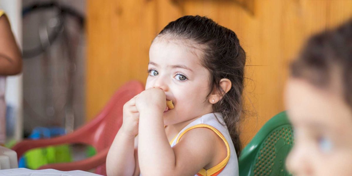 Criança lanchando um fruta